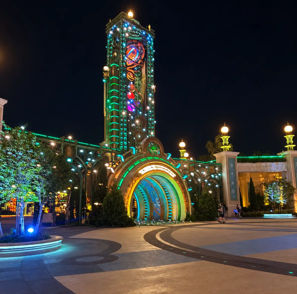 The Chronos tower and entrance portal at Universal Epic Universe lit up at night during Universal Nights