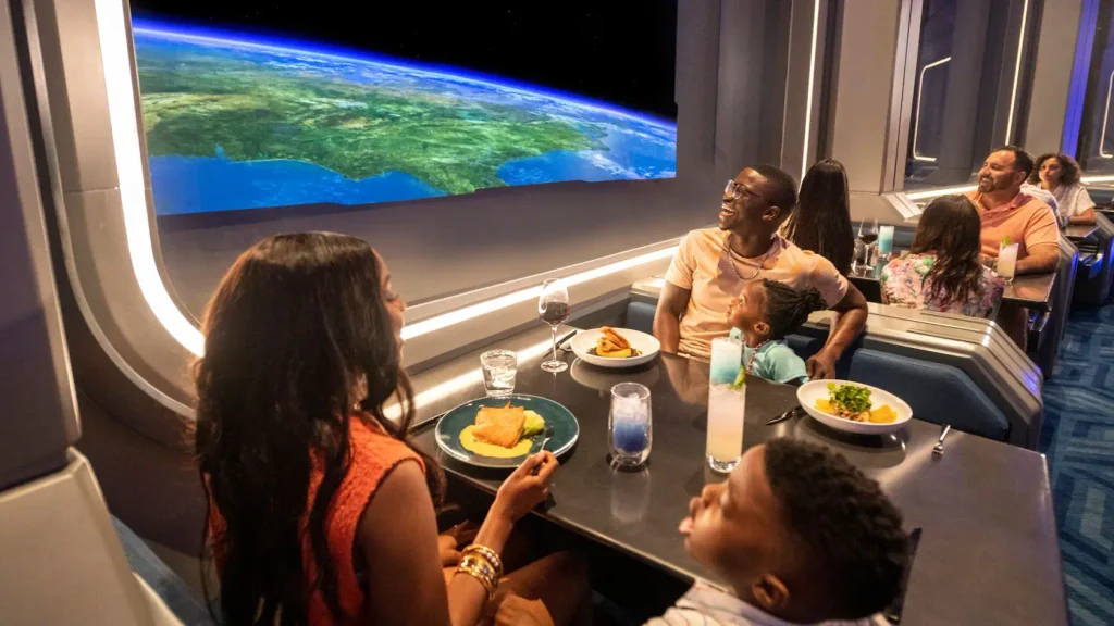 A family enjoys one of the best Disney World dining experiences at a restaurant with a panoramic window showing a view of Earth from space. - Favorite Grampy Travels