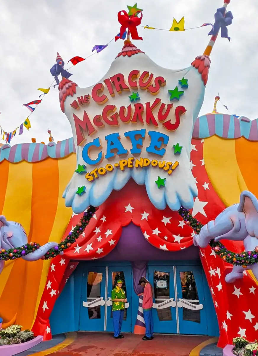 Circus McGurkus Cafe Stoo-pendous entrance with Grinchmas garland and a Who greeter at the doors in Seuss Landing